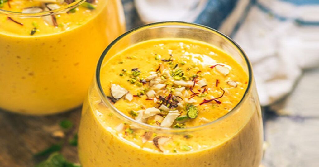 Close-up of Mango Lassi garnished with chopped nuts and saffron strands