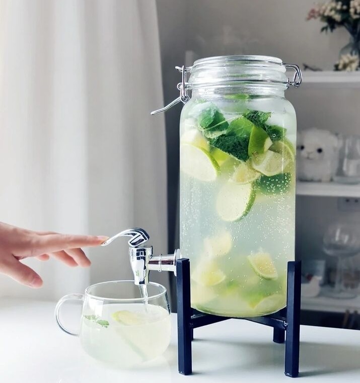 A refreshing mojito served in a mason jar, garnished with fresh mint leaves and lime slices, with a black straw.