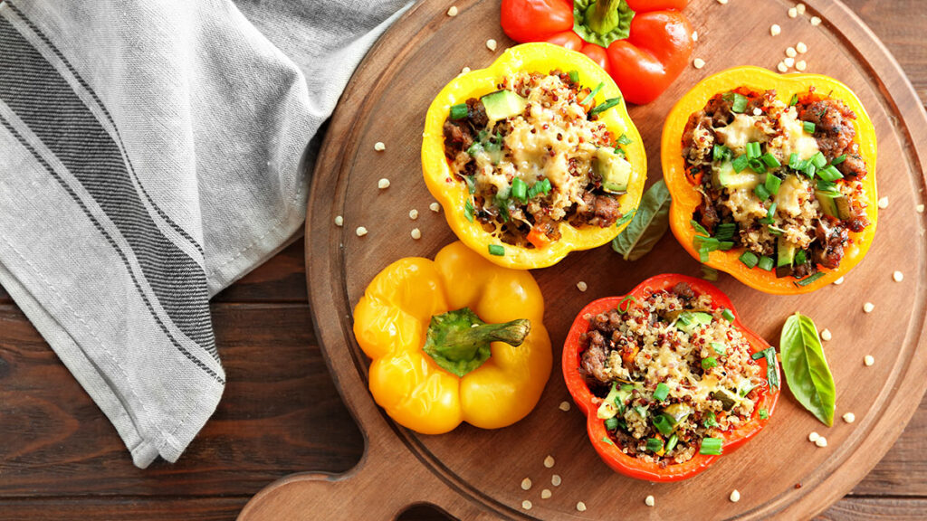 Stuffed Bell Peppers with Quinoa and Black Beans served on a wooden platter