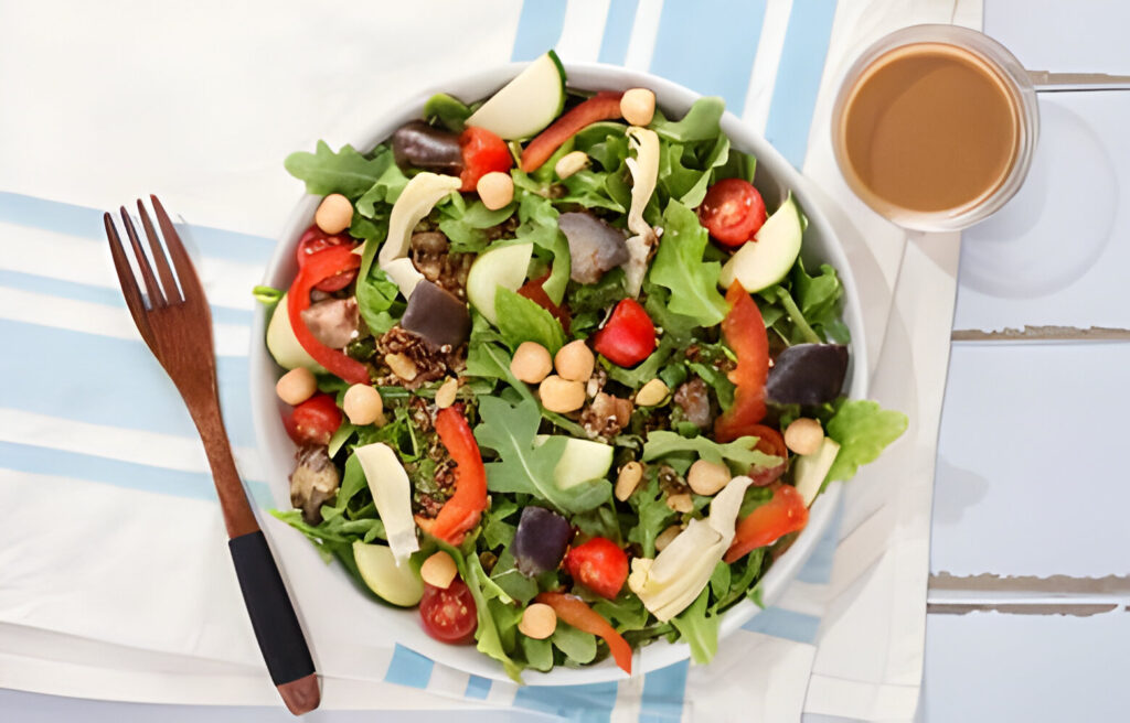 A bowl filled with a colorful Mediterranean quinoa salad with cherry tomatoes, cucumber, olives, and feta cheese.