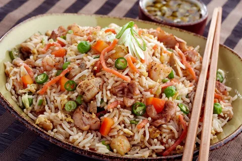 Delicious teriyaki chicken fried rice with veggies and chopsticks - a flavorful culinary adventure!