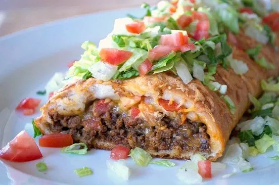 A delicious taco braid filled with seasoned ground beef, melted cheese, and topped with fresh lettuce and diced tomatoes.