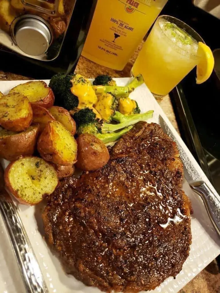 Juicy marinated steak served with roasted potatoes, broccoli, and a refreshing citrus cocktail