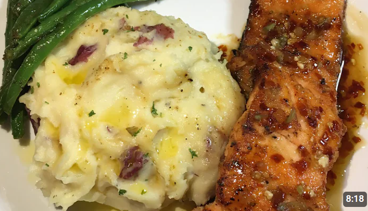 Plate of creamy Gouda cheese mashed potatoes served with grilled salmon and green beans