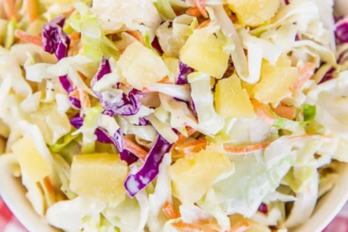 Close-up of colorful pineapple coleslaw with shredded cabbage, carrots, and pineapple chunks