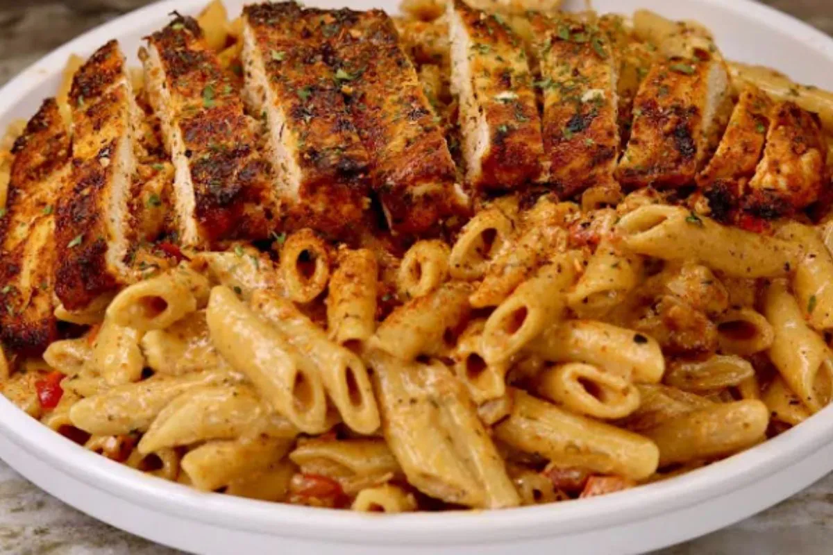 Plate of creamy Cajun chicken pasta with grilled chicken slices and penne pasta in a rich, spicy sauce