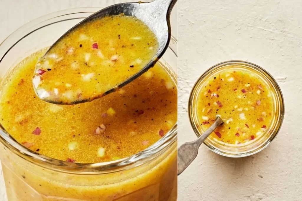 Closeup of homemade orange vinaigrette dressing in a glass jar with a spoon, showing vibrant color and texture