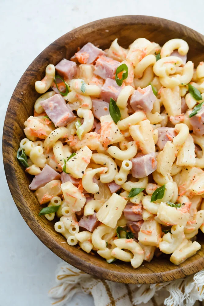 Bowl of Mexican-inspired macaroni salad with ham, vegetables, and cilantro in a creamy dressing