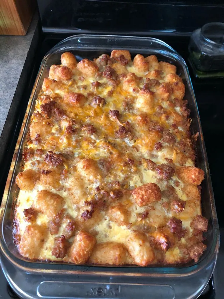 Freshly baked tater tot casserole in a glass baking dish, golden brown and cheesy